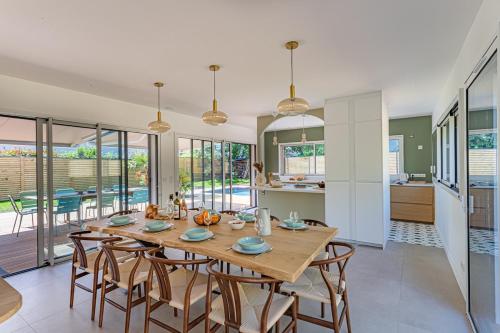 une cuisine et une salle à manger avec une table et des chaises en bois dans l'établissement Une parenthèse enchantée à Larmor-Baden, à Larmor-Baden
