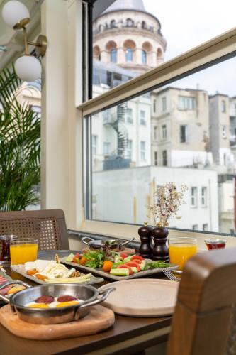 a table with plates of food on a table with a window at Querencia Hotel in Istanbul