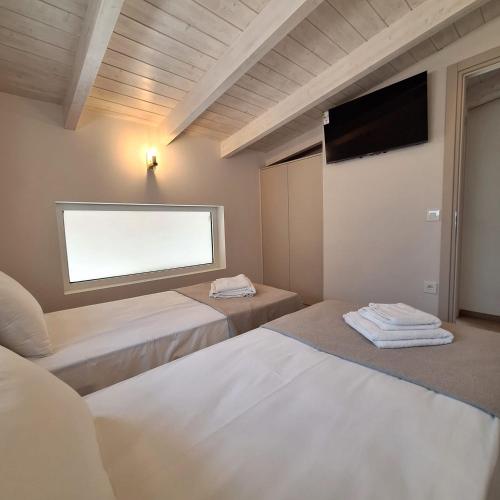 a room with two beds and a flat screen tv at Azzurro Mare in Póndi