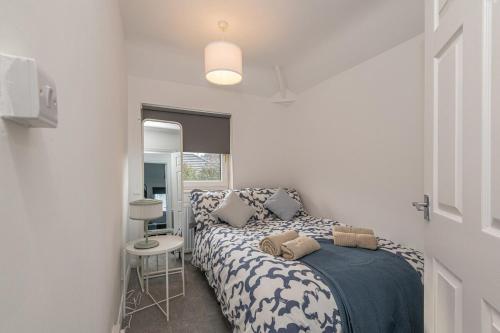 a bedroom with a bed with a blue and white blanket at Spacious 5 Bed Close to Elland Road, First Direct Arena & Headingley Stadium in Roundhay