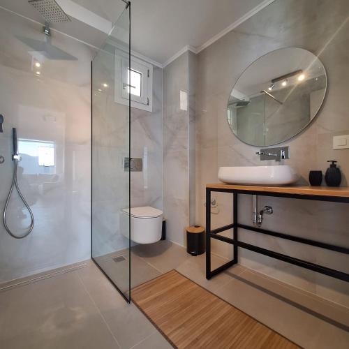a bathroom with a shower and a sink and a mirror at Azzurro Mare in Póndi