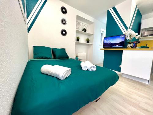 - une chambre avec un lit vert et 2 serviettes dans l'établissement Color Studio - Proche Gare - 2P, à Belfort
