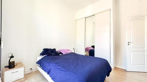 une chambre avec un lit bleu et un miroir dans l'établissement Nice deux pieces, à Nice