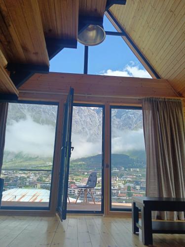 a room with large windows with a view of a mountain at My house in Stepantsminda
