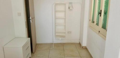 a room with white walls and a tiled floor at Private room in shared flat in Nicosia