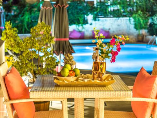 a table with a tray of fruit and a vase of flowers at Kalkan Suites Hotel in Kalkan