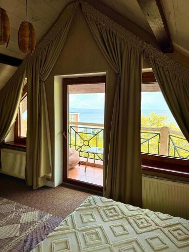 a bedroom with a bed and a window with a balcony at Villa Sofia in Odesa
