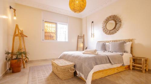 Un dormitorio con una cama grande y un espejo. en Sable beach surf camp Tamraght, en Tamraght Ouzdar