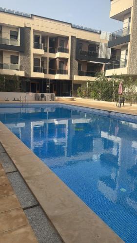 a large swimming pool in front of a building at Appartement vus sur piscine saidia in Saidia 