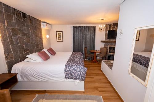 a bedroom with a bed and a living room at Villa Hegus chales com hidro ar lareira in Campos do Jordão