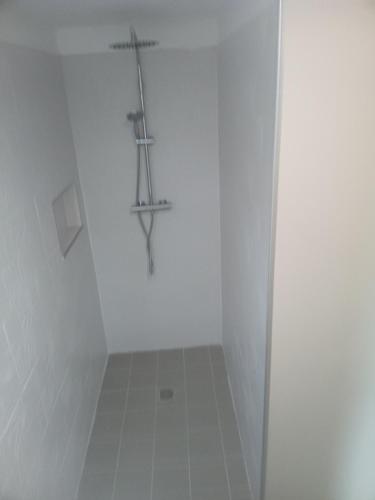 a white bathroom with a cross on the wall at La garçonnière in Gesvres