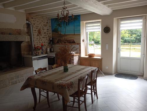 a kitchen with a table and chairs in a room at La garçonnière in Gesvres