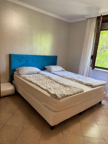 a large bed in a bedroom with a blue headboard at Santa Marina Apartment 503 in Sozopol