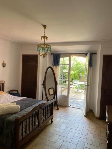 - une chambre avec un lit, un miroir et une porte dans l'établissement Maison Juliana centre village et navette plage, à La Croix-Valmer