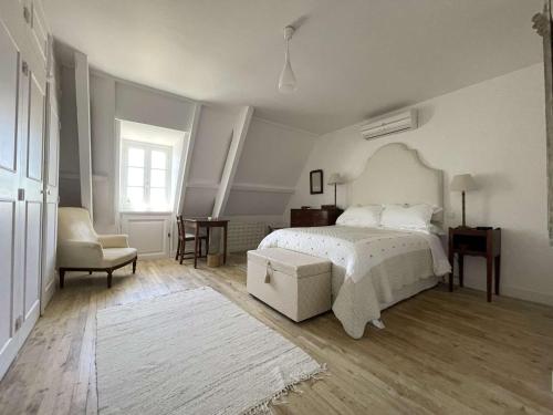 une chambre blanche avec un lit et une chaise dans l'établissement Maison de campagne avec piscine privée et parking à Sainte Alvère - FR-1-824-4, à Lentignac