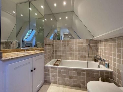 une salle de bain avec une baignoire, un lavabo et des toilettes dans l'établissement Maison de campagne avec piscine privée et parking à Sainte Alvère - FR-1-824-4, à Lentignac