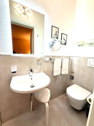 a bathroom with a white sink and a toilet at Villa Le Camelie Siena in Siena