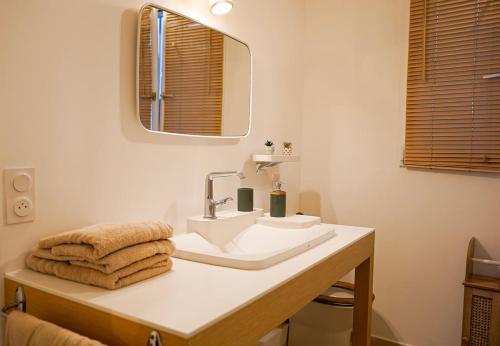 une salle de bain avec un lavabo, un miroir et des serviettes dans l'établissement La Casa Miguel, à Avignon