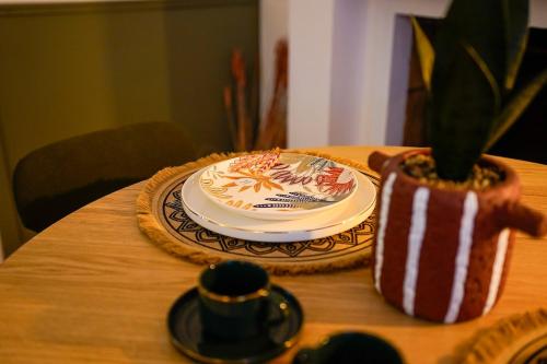 une table avec une plaque et une plante en pot dans l'établissement La Casa Miguel, à Avignon
