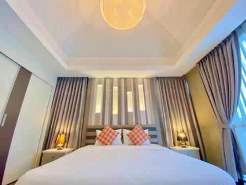 a bedroom with a large bed with two pillows at Holiday Pool Villa Pattaya in Pattaya Central