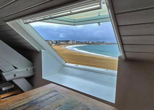 Cette chambre avec fenêtre offre une vue sur la plage. dans l'établissement Appartement vue mer, Centre-ville & plage, à Quiberon