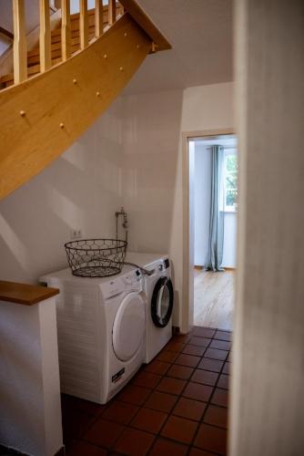 a washing machine in a room with a staircase at Schönstes kleines Ferienhaus in der Lü-Heide in Egestorf