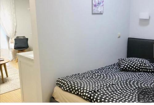 a bedroom with a black and white bed and a table at Happy Inn Sweet Old Town Studio, Self check in, Parking in Vilnius