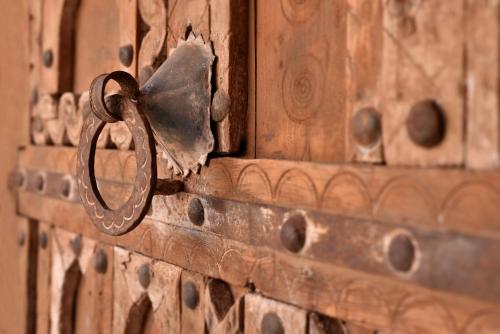 a wooden door with a metal latch on it at Dar Syada Boutique Hotel Marrakech in Marrakech