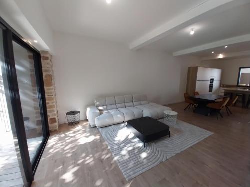 ein Wohnzimmer mit einer weißen Couch und einem Tisch in der Unterkunft Maison moderne proche de la gare de Vannes in Saint-Avé