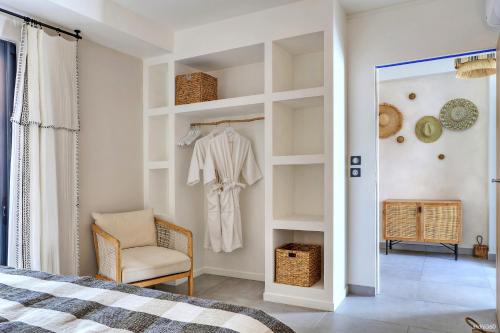 a bedroom with a bed and a chair and a mirror at Villa Kintana - Piscine - SPA - Prestations 5 Etoiles in Petite Île