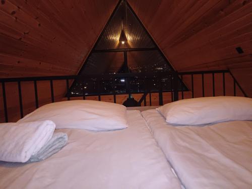 a bed with white pillows in a room with a window at My house in Stepantsminda