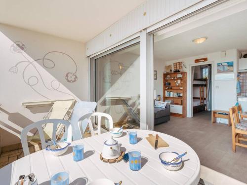 une table blanche avec des tasses bleues dessus dans une pièce dans l'établissement Studio cabine à Carnac - Vue mer - Animaux acceptés - FR-1-477-262, à Carnac