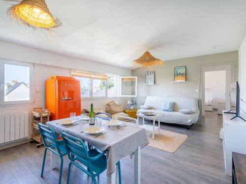 un salon avec une table et des chaises bleues dans l'établissement Carnac : Bel Appartement 43m², 2 Pièces, Wifi Inclus, Proche Plage - FR-1-477-261, à Carnac