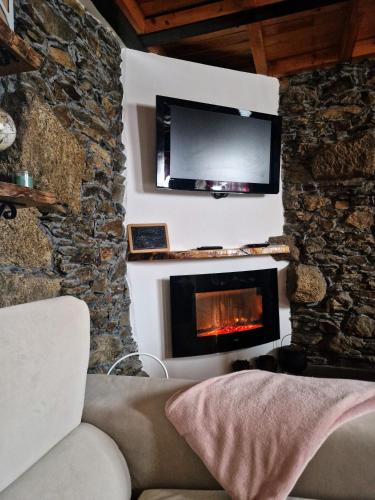 a living room with a tv and a fireplace at Sweet Côa in Sabugal