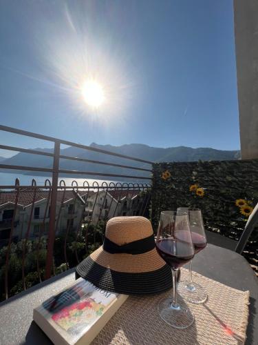a hat and two glasses of wine on a table at Apartman Nina2 in Risan