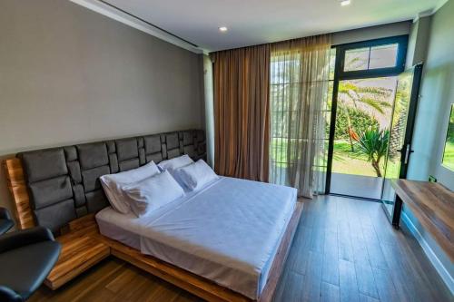 a bedroom with a large bed and a window at Dachis Villa Private Pool Retreat in Batumi