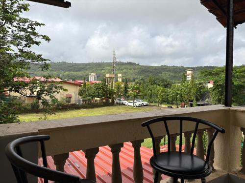 balcone con 2 sedie e vista sulla città di Capricorn villa a Lonavala