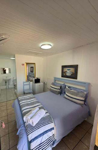 a bedroom with a large bed with striped pillows at Swallow13 in Centurion