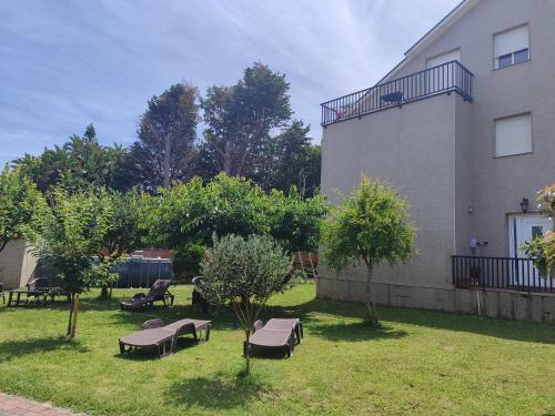 a yard with benches and trees next to a building at O vilar apartamentos n6 in Villalonga