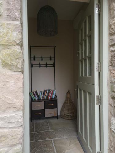a hallway with a door and a shelf with books at Converted cattle barn overlooking Strangford Lough in Newtownards