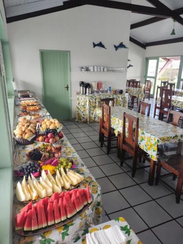 a buffet line with many plates of fruit on tables at Hotel Porto Verde -JG in Porto Seguro