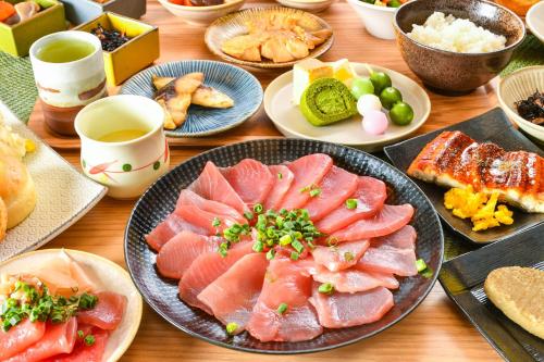 a wooden table with plates of food on it at Sanco Inn Shizuoka Kitaguchi in Shizuoka