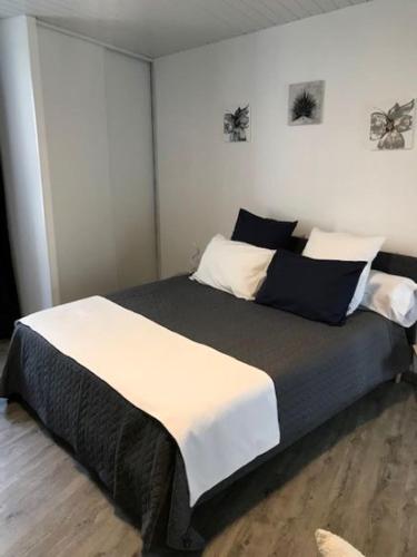 - une chambre avec un grand lit noir et blanc dans l'établissement les gites de KALY, à Bélesta