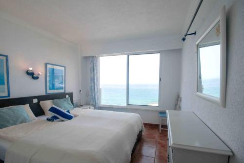 a bedroom with a bed and a large window at Ferienwohnung am Strand - 2 Schlafzimmer in Arguineguín