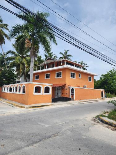 ein orangefarbenes Gebäude mit Palmen am Straßenrand in der Unterkunft Cómodo y cerca de la playa in Punta Cana
