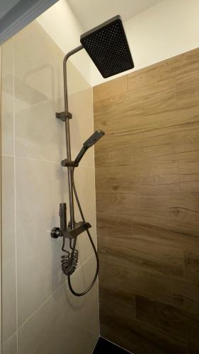 La salle de bains est pourvue d'une douche et d'une lumière sur le mur. dans l'établissement Maisonnette climatisée avec jardin proche océan, à Saint-André-de-Lidon