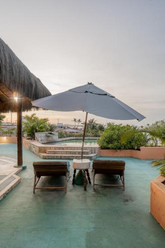 a table and two benches with an umbrella at Dayo Hotel in Flecheiras