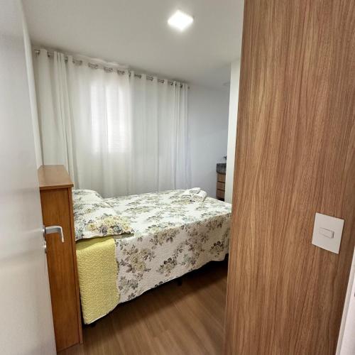 a small bedroom with a bed and a wooden door at Flor Prime Loft in Extrema
