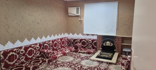 a living room with a couch and a fireplace at مساكن الخليج in Unayzah