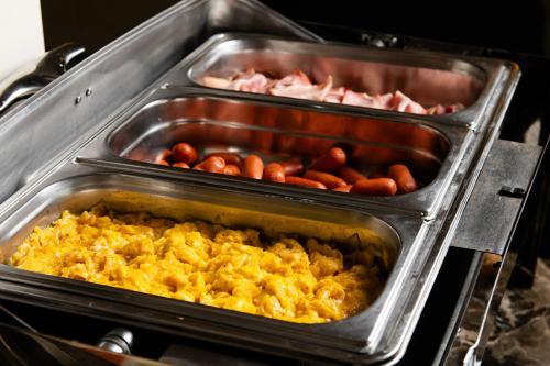 two trays of food in an oven at Heaven Hotel Thessaloniki Airport in Néon Rýsion